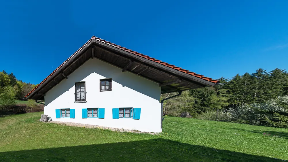 Bauernhaus Eckhütt Eins — Front durch einen Baum gerahmt