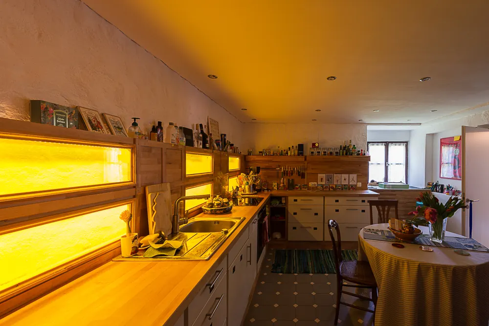 Wohnküche im Bauernhaus mit Holztisch, Kochzeile und Fliesenboden